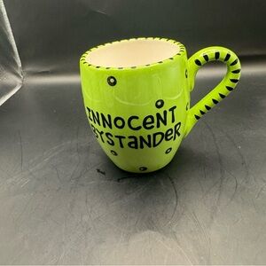 Lorrie Veasey Green Polka Dotted “Innocent Bystander” Mug By Our Name Is Mud